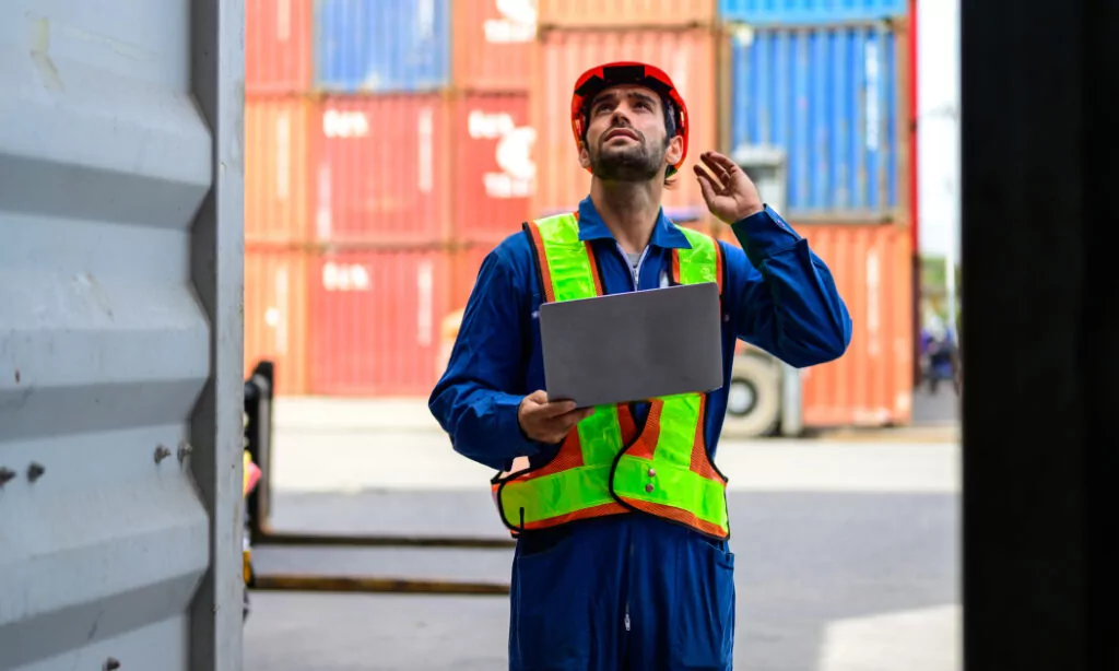 worker in hard hat performing gate checkpoint services on intermodal containers