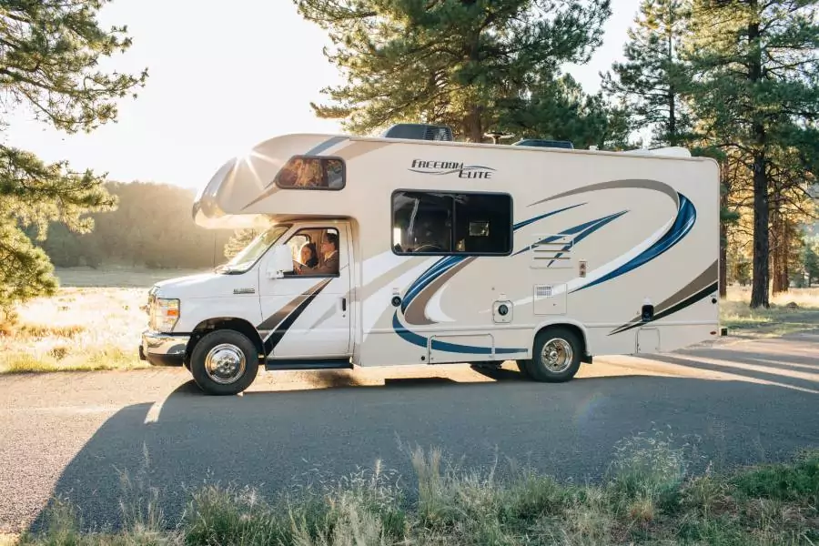 Couple seated in a Recreational Vehicle driving on road