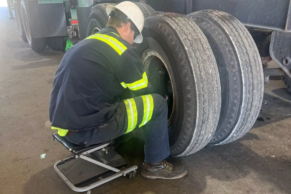P&B employee wearing a hard hat repairing tires